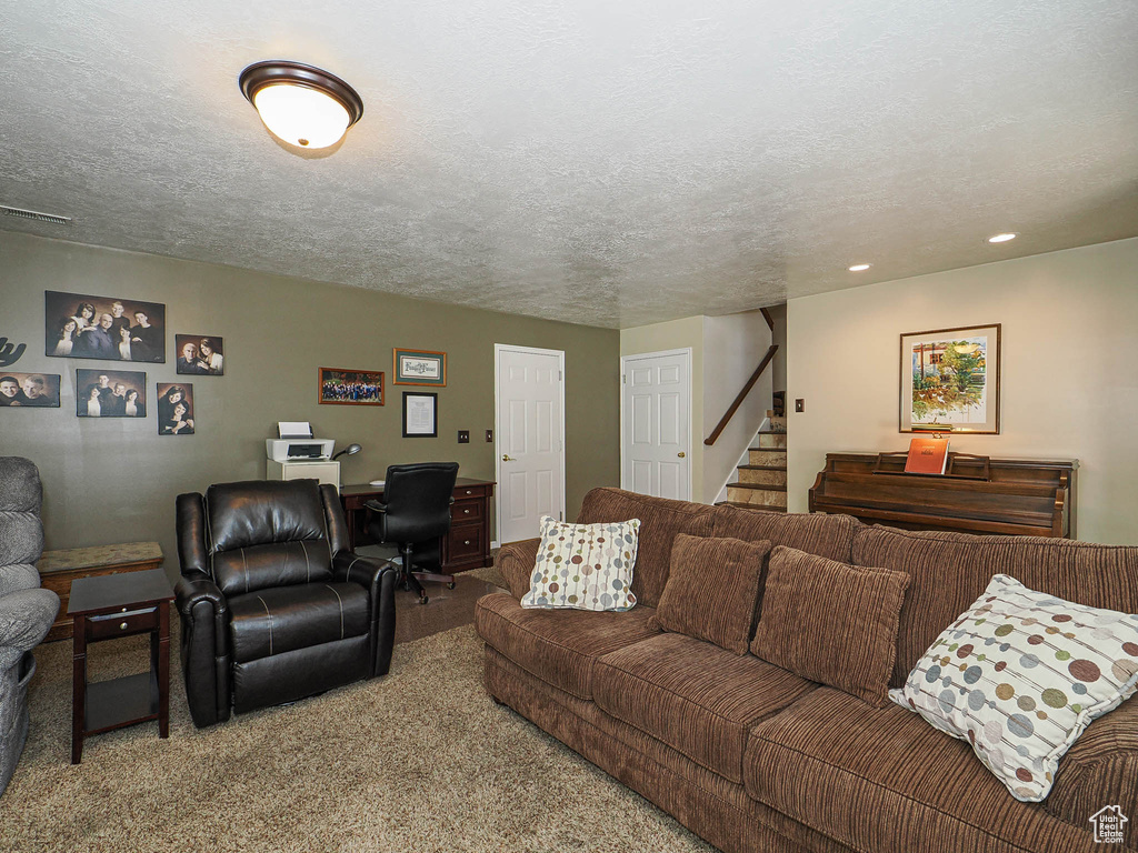 Carpeted living room with recessed lighting, a textured ceiling, and stairway