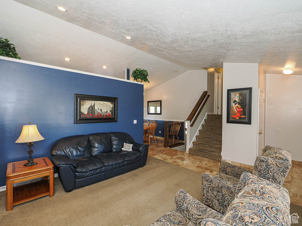 Carpeted living room featuring recessed lighting, vaulted ceiling, stairs, and a textured ceiling