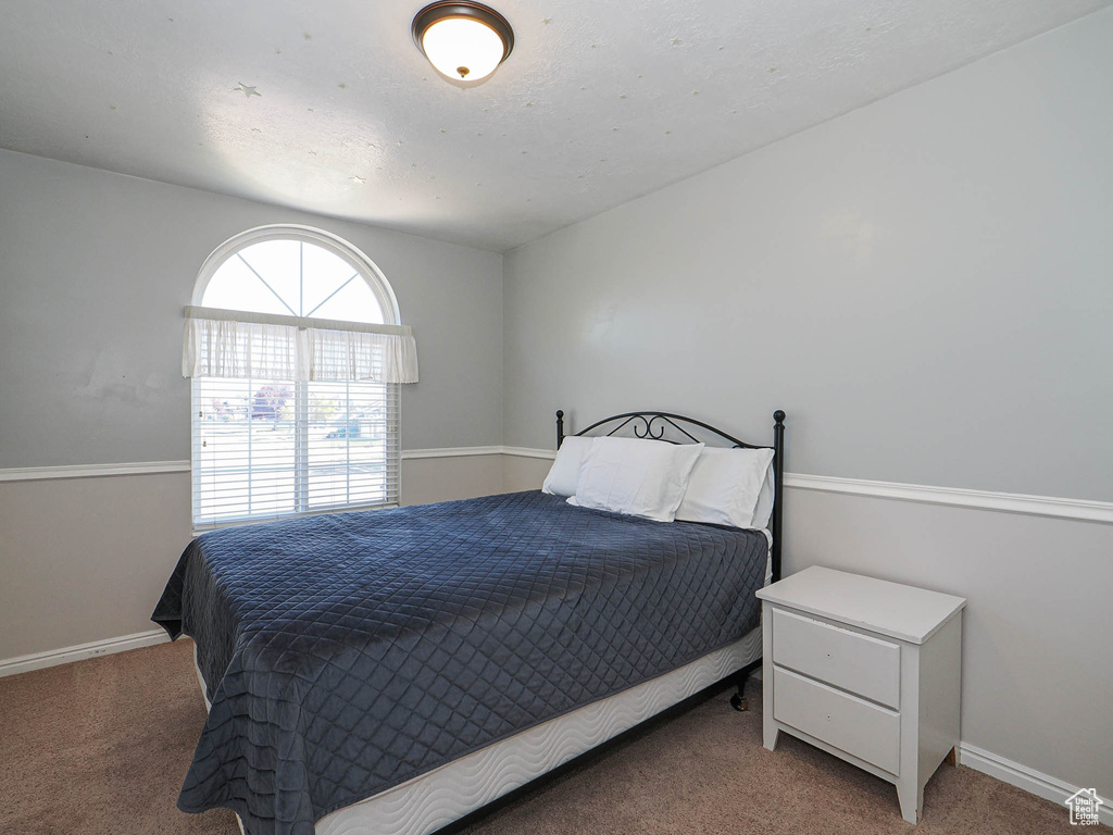 Bedroom featuring carpet flooring and baseboards