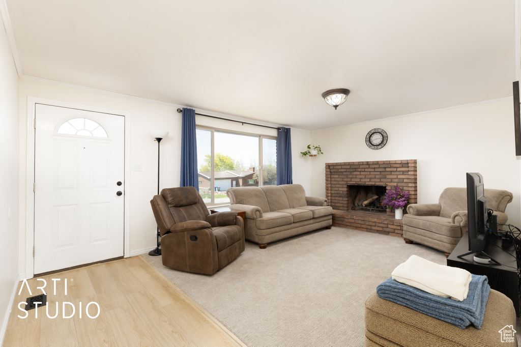Living area featuring ornamental molding, a fireplace, and wood finished floors