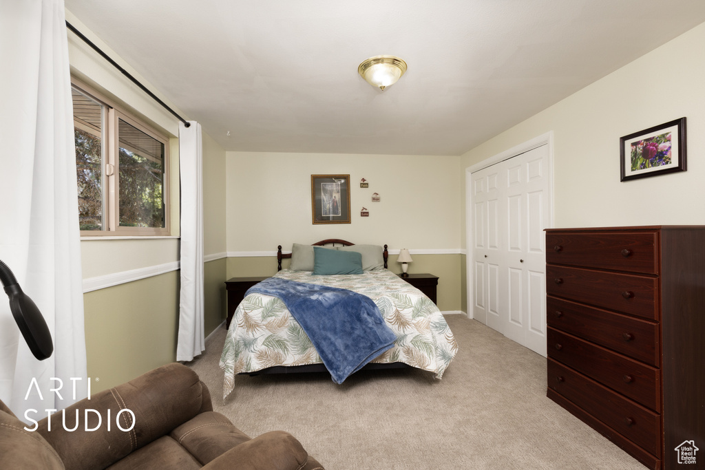 Bedroom featuring light carpet and a closet