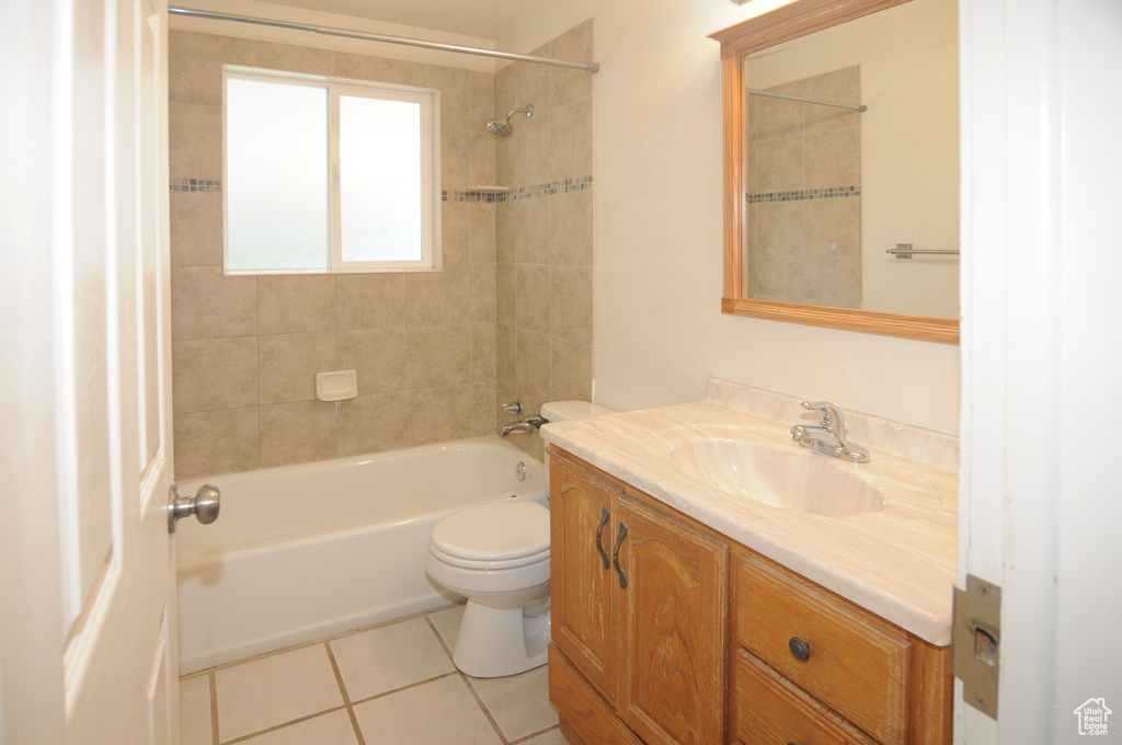 Bathroom with tile patterned floors, vanity, toilet, and shower / washtub combination