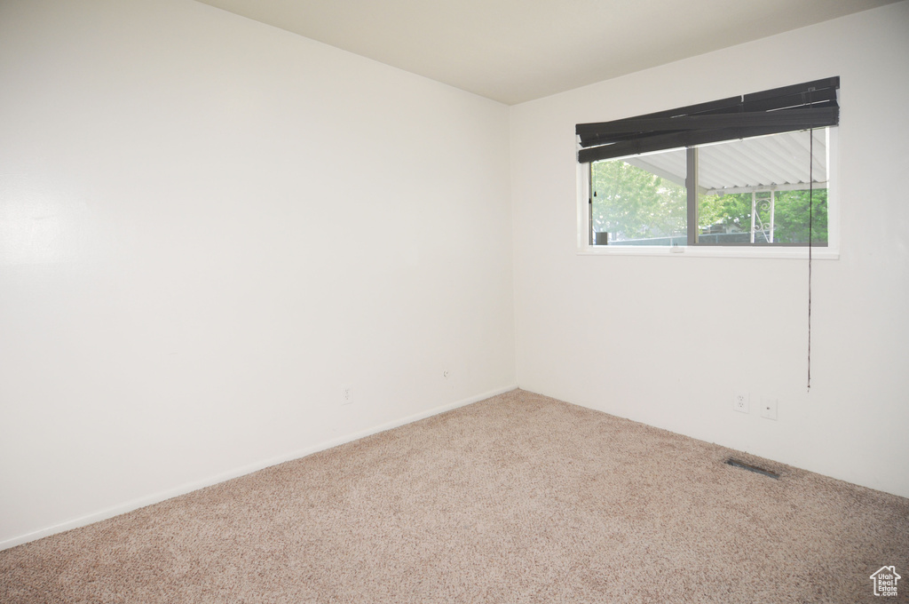 Carpeted empty room with visible vents