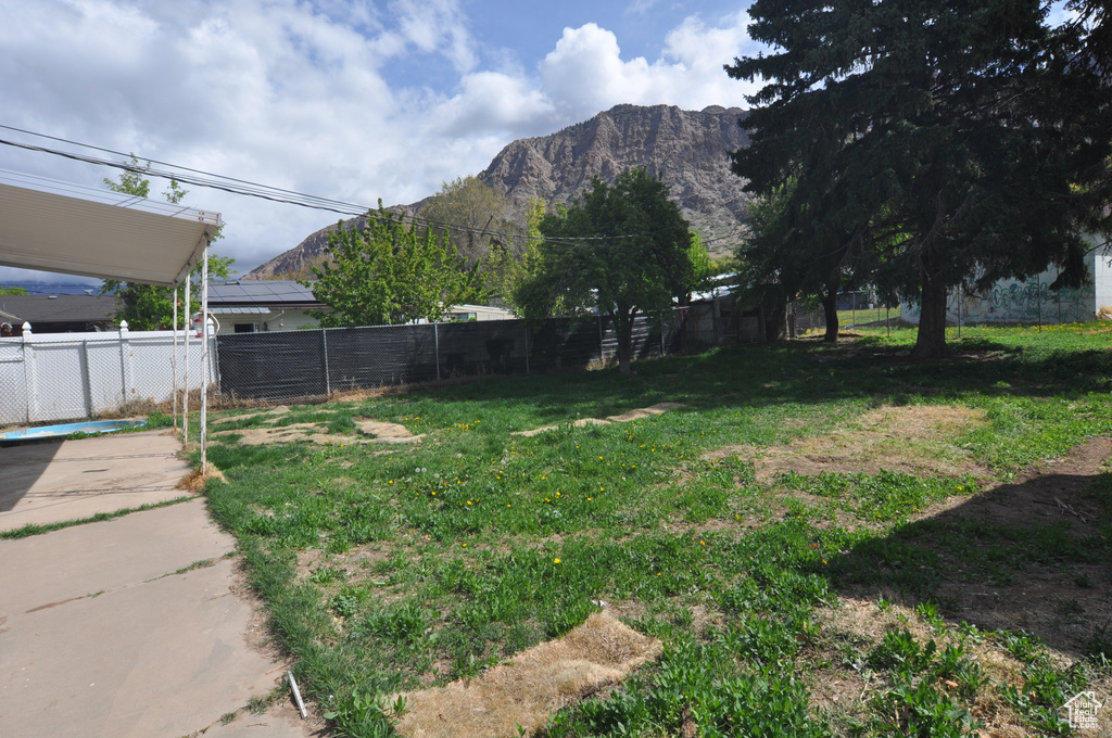 View of yard with a mountain view and fence