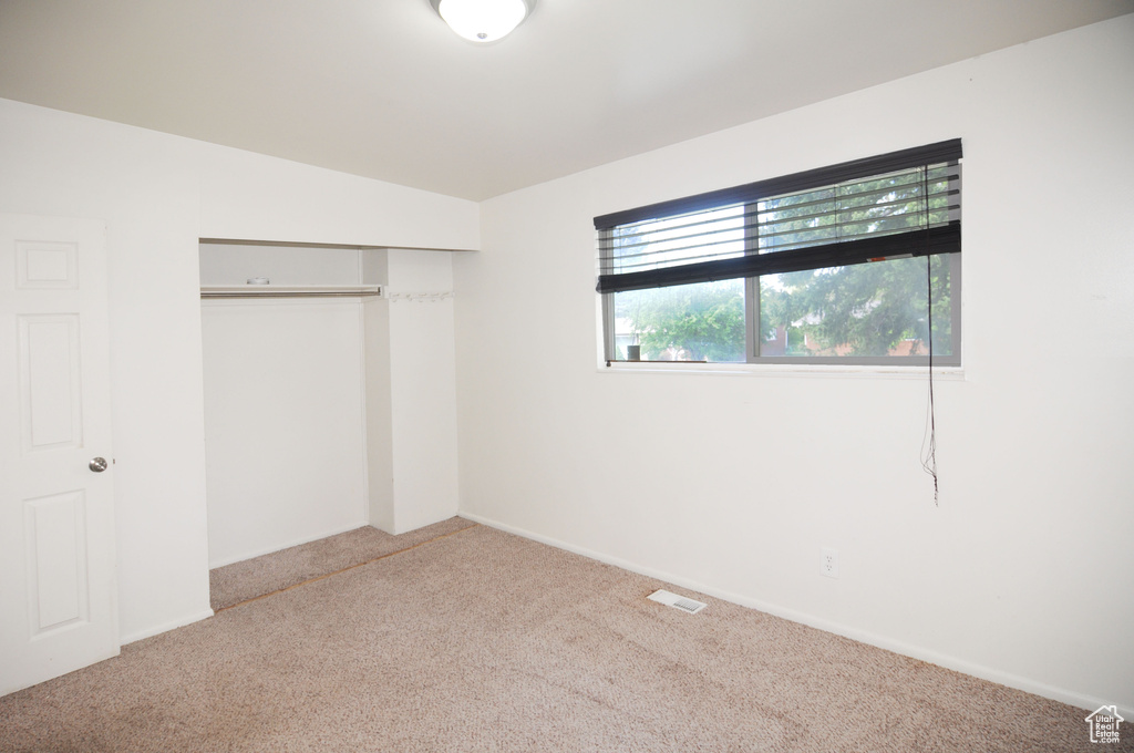 Unfurnished bedroom featuring visible vents, a closet, and carpet flooring