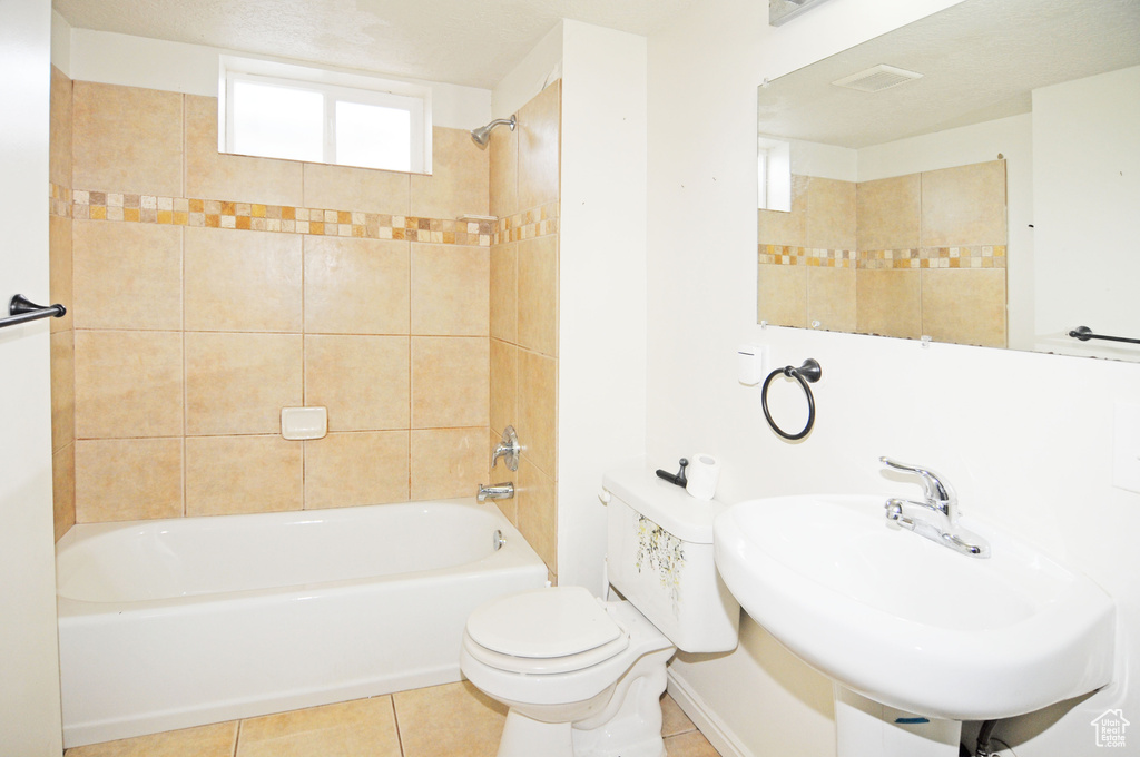 Bathroom with toilet, a sink, bathtub / shower combination, and tile patterned floors