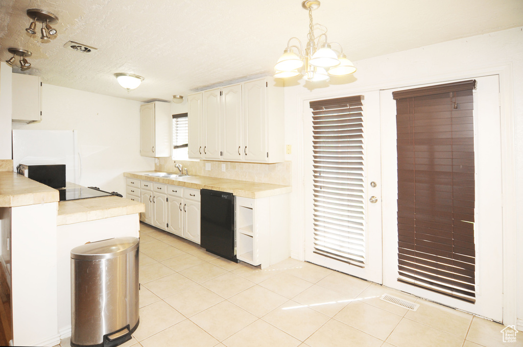 Kitchen with tile counters, dishwasher, light tile patterned floors, and a sink
