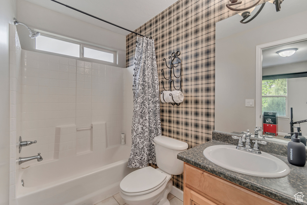 Full bath with shower / bath combo with shower curtain, wallpapered walls, a wealth of natural light, and toilet