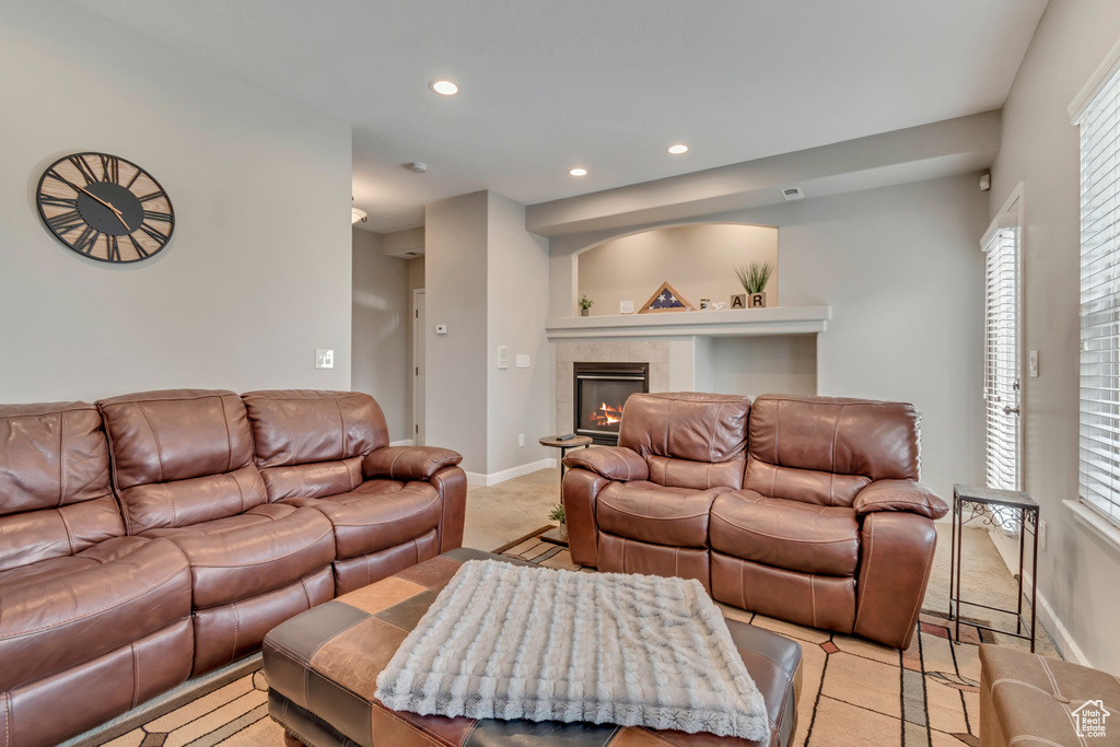 Living room featuring baseboards, light carpet, recessed lighting, and a tile fireplace