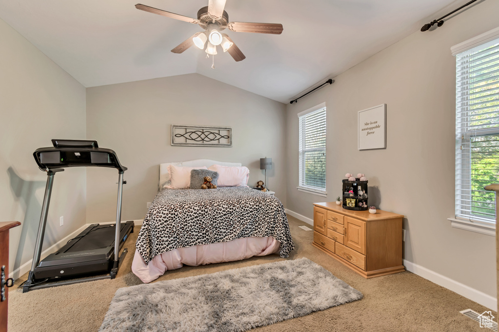 Bedroom with carpet flooring, baseboards, visible vents, and lofted ceiling