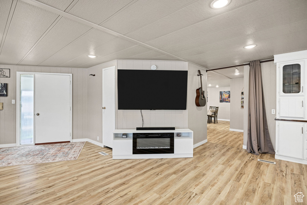 Unfurnished living room featuring baseboards, recessed lighting, and light wood finished floors
