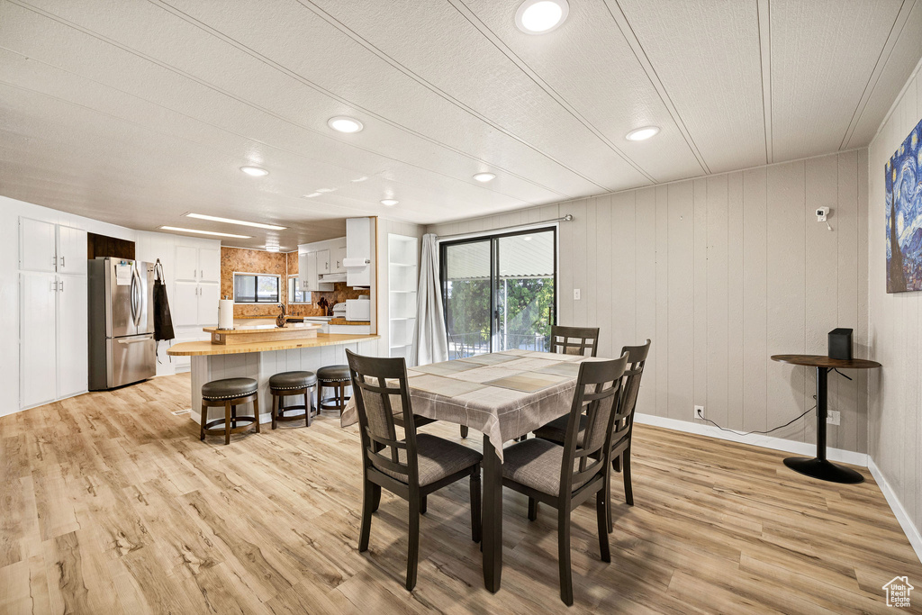 Dining room with recessed lighting, light wood finished floors, and baseboards