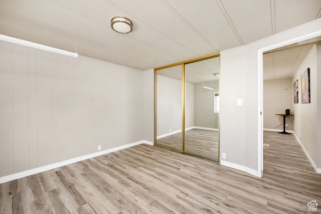 Unfurnished bedroom with a closet, baseboards, and wood finished floors