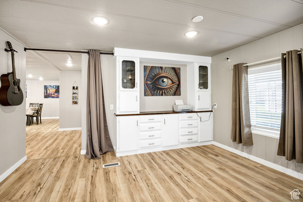Interior space with light wood-style floors, baseboards, and visible vents