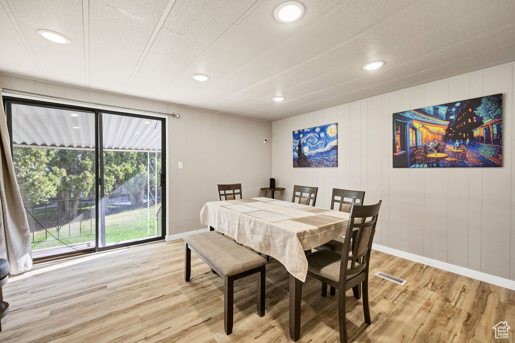 Dining area with visible vents, light wood-style flooring, and baseboards