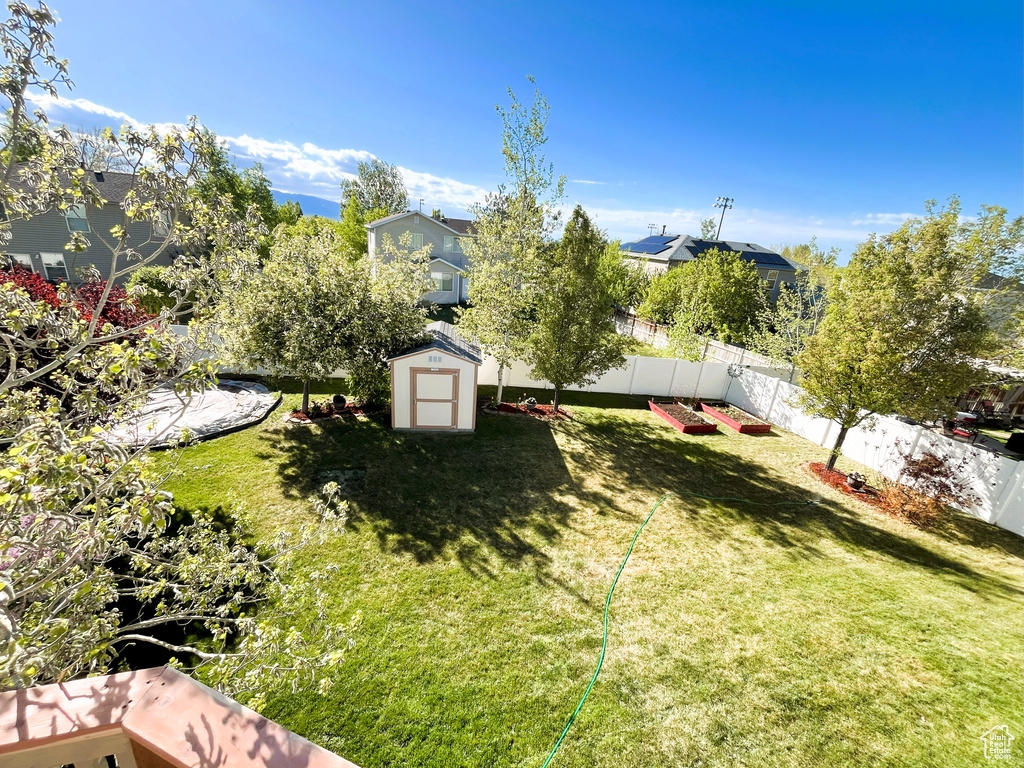 View of yard featuring a fenced backyard, a storage unit, and an outdoor structure