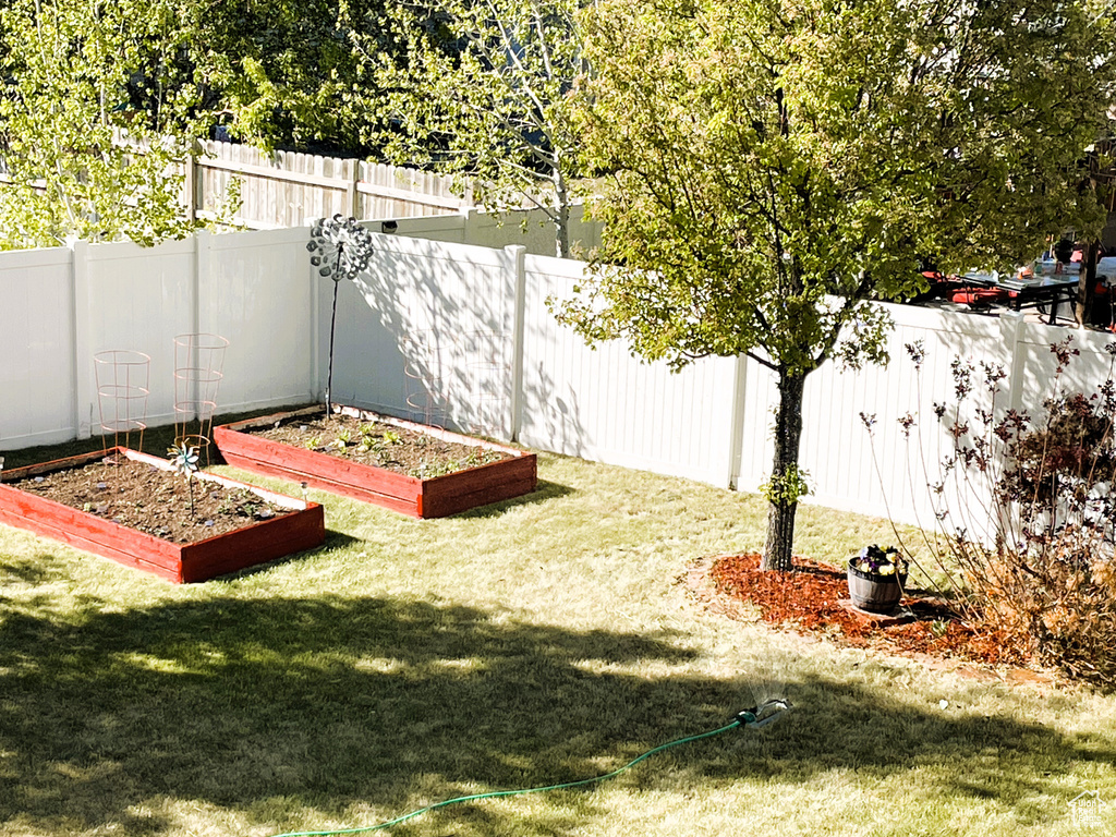 View of yard with a fenced backyard and a vegetable garden