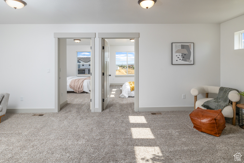 Carpeted bedroom featuring baseboards and visible vents