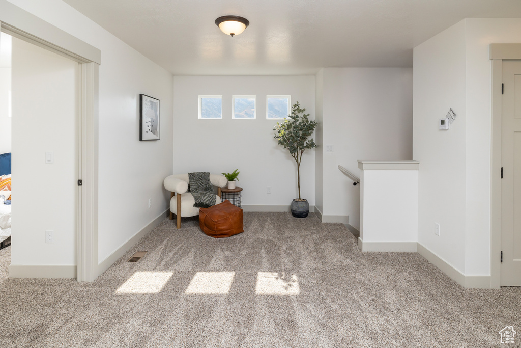 Sitting room with baseboards, carpet flooring, and an upstairs landing