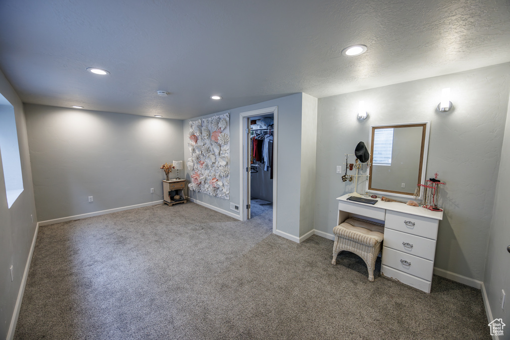 Interior space with baseboards, recessed lighting, a textured ceiling, a spacious closet, and carpet flooring