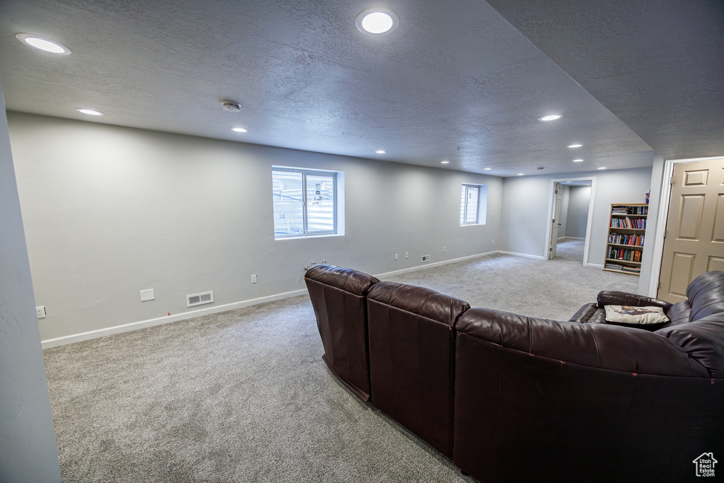 Living area with recessed lighting, visible vents, and carpet