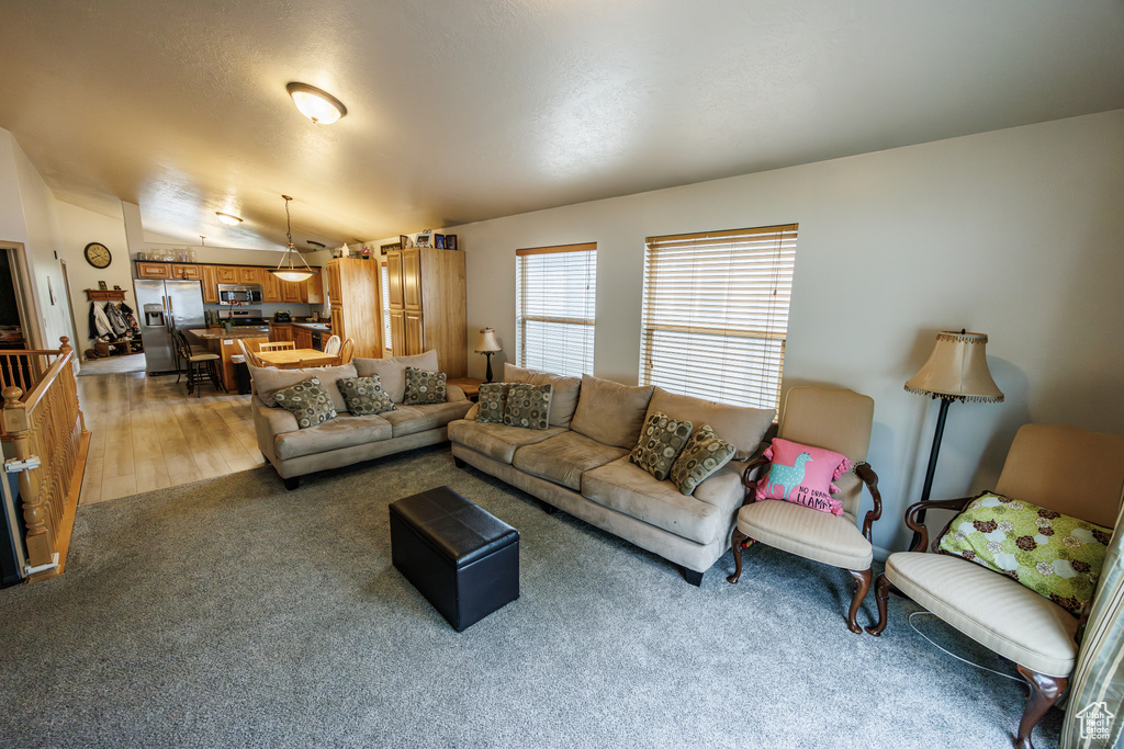 Living room with light carpet and lofted ceiling