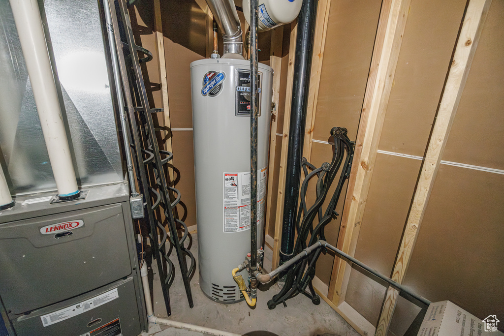 Utility room featuring heating unit and water heater