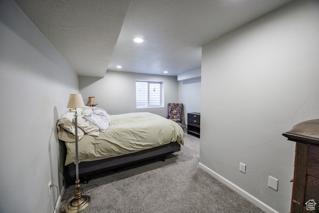 Carpeted bedroom featuring recessed lighting, a textured ceiling, and baseboards