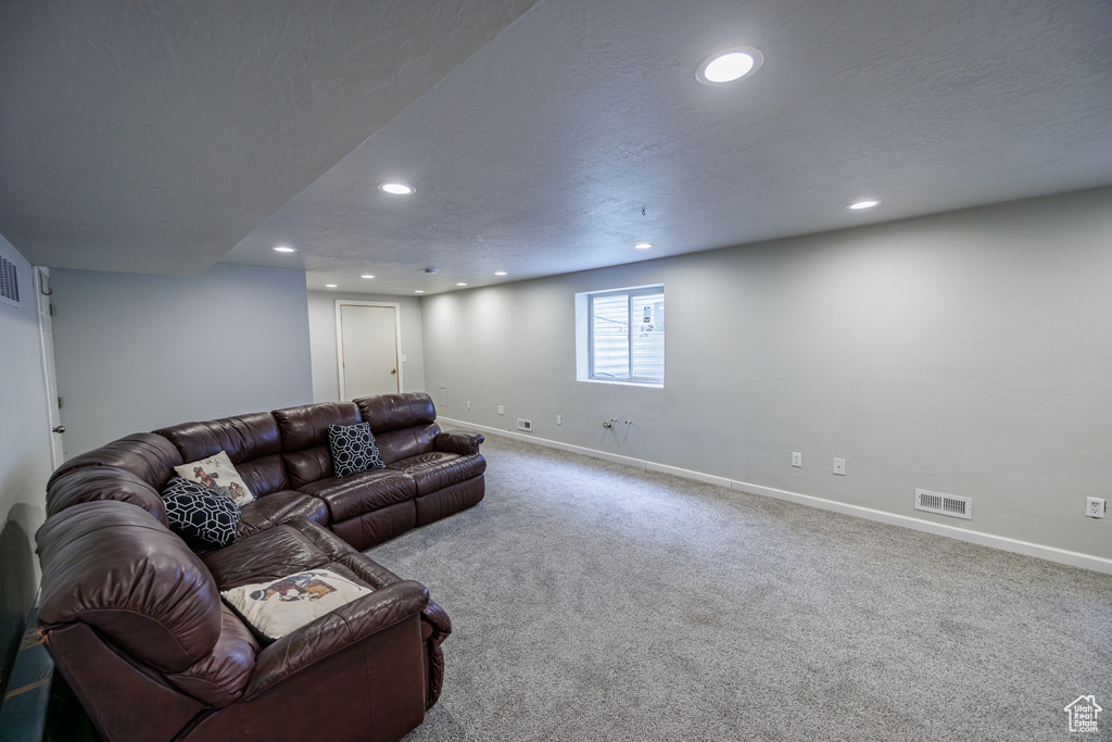 Carpeted living room with baseboards, recessed lighting, and visible vents