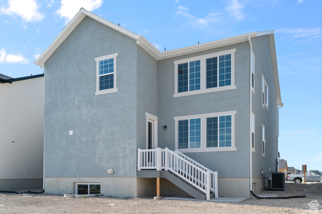 Back of house with central AC and stucco siding