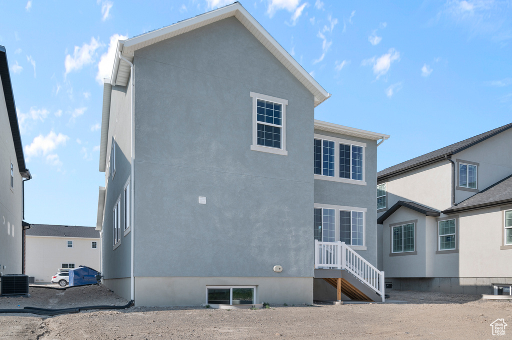 Back of house featuring central AC and stucco siding