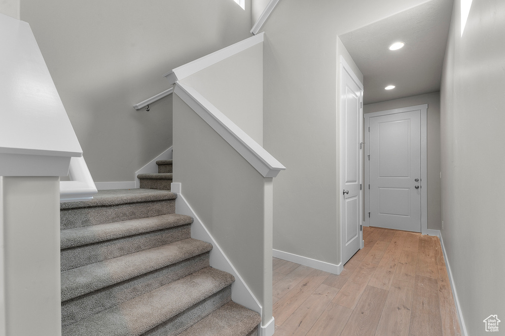 Stairs with hardwood / wood-style flooring, recessed lighting, and baseboards