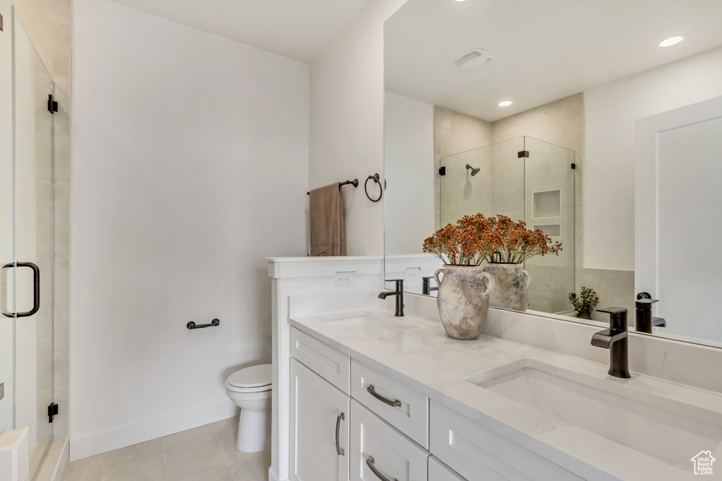Full bath with a sink, a stall shower, tile patterned floors, and toilet