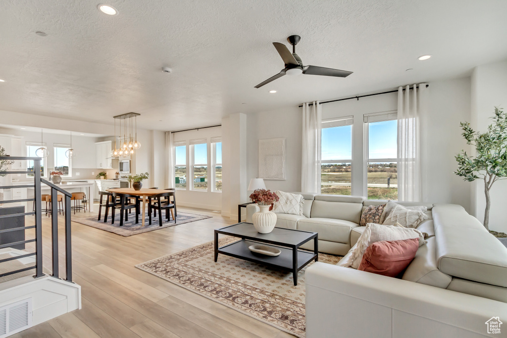 Living area featuring visible vents, ceiling fan, recessed lighting, a textured ceiling, and light wood-style flooring