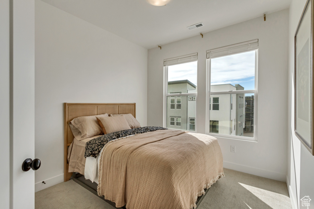 Carpeted bedroom featuring baseboards and visible vents