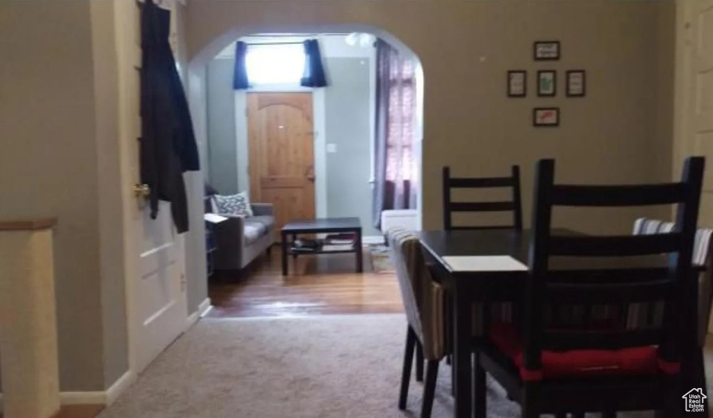 Carpeted dining room with baseboards and arched walkways