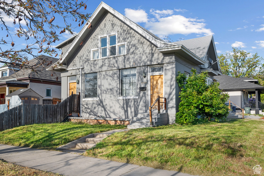 Bungalow-style house with a front lawn and fence