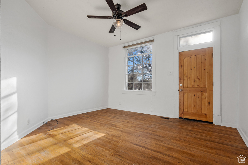 Foyer featuring baseboards, a ceiling fan, wood finished floors, and visible vents