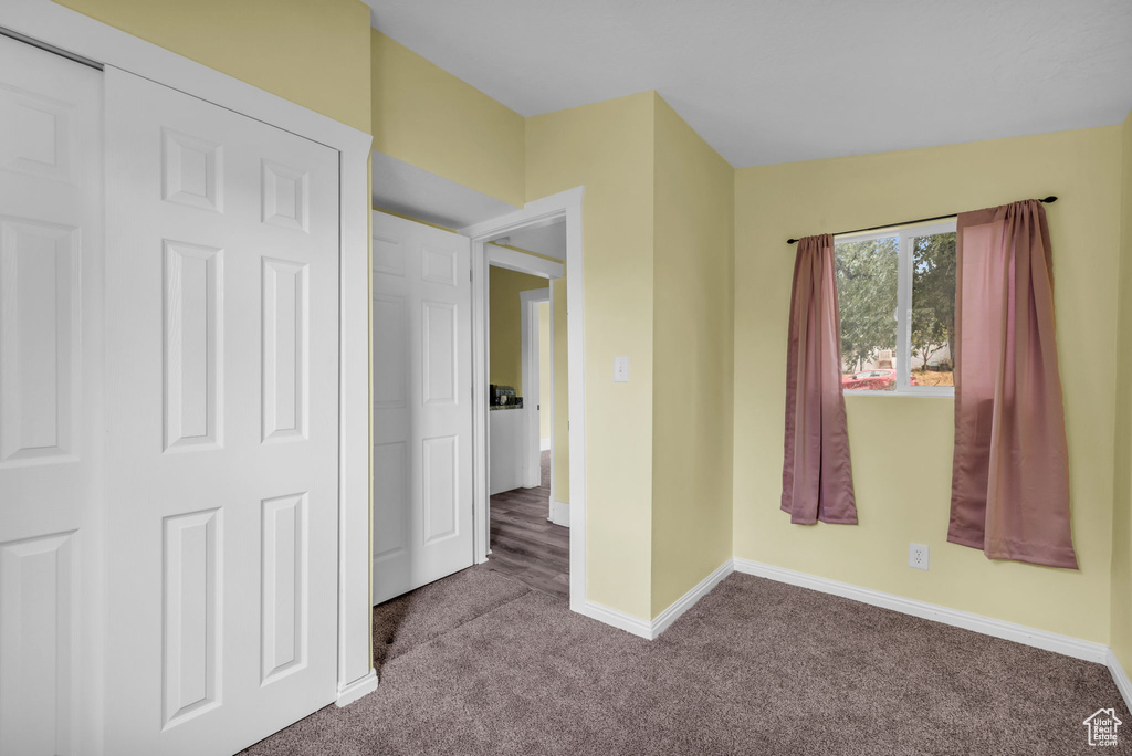 Unfurnished bedroom featuring carpet floors and baseboards