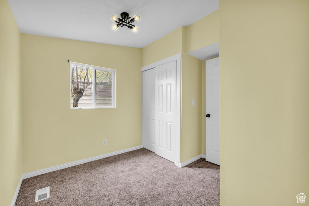 Unfurnished bedroom featuring visible vents, carpet flooring, baseboards, and a closet