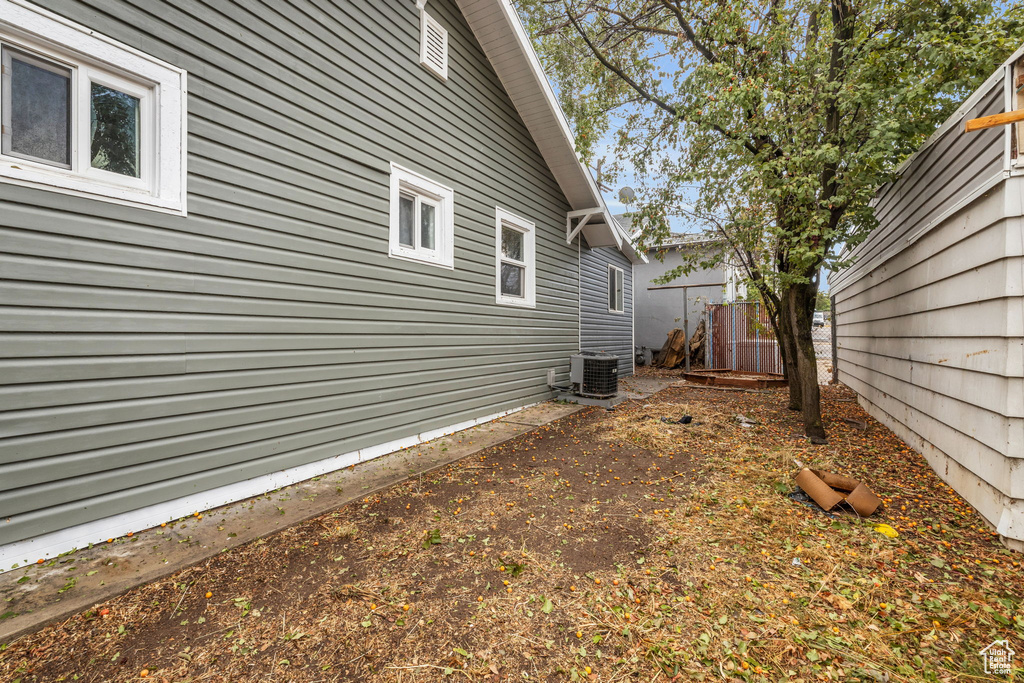 View of side of property with fence and cooling unit