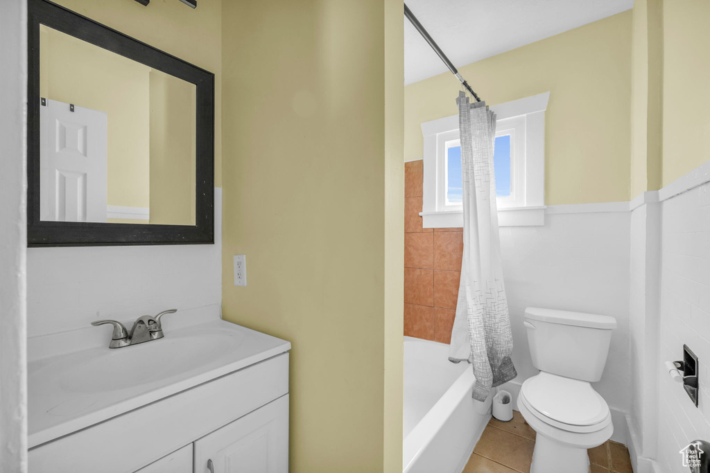 Full bath featuring toilet, shower / bathtub combination with curtain, tile patterned flooring, and vanity