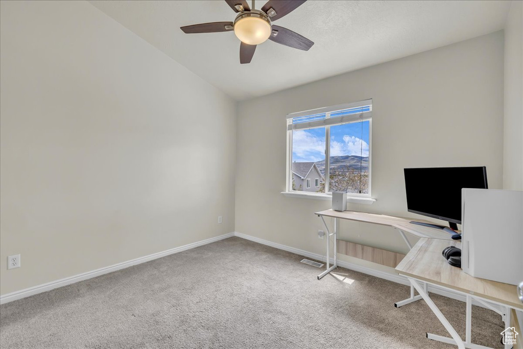 Unfurnished office featuring a ceiling fan, visible vents, vaulted ceiling, baseboards, and carpet flooring