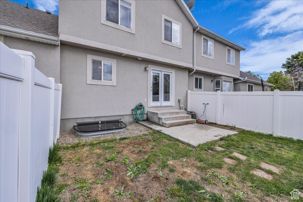 Back of property featuring a fenced backyard, a patio, and stucco siding