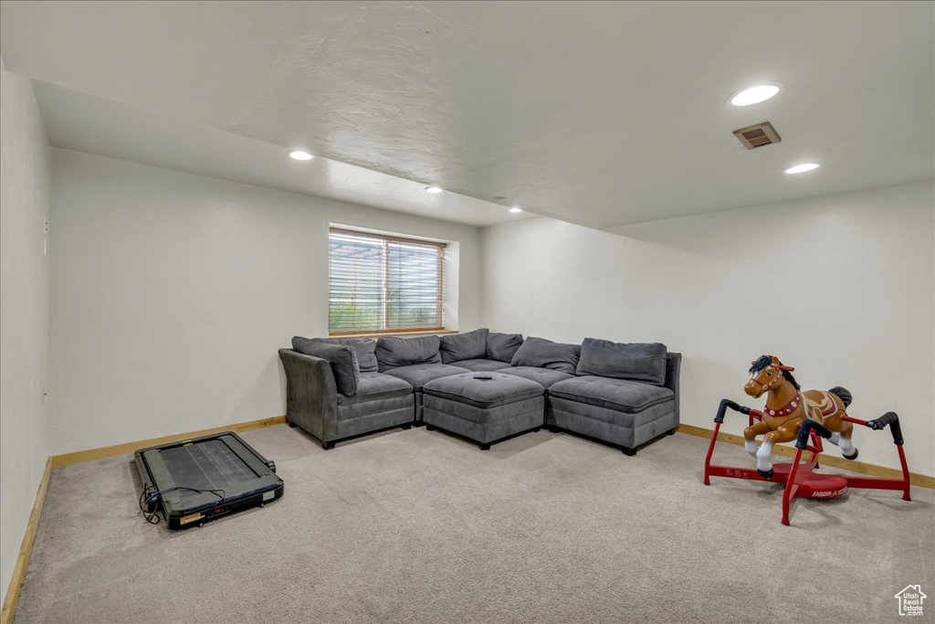 Carpeted living room with baseboards, recessed lighting, and visible vents