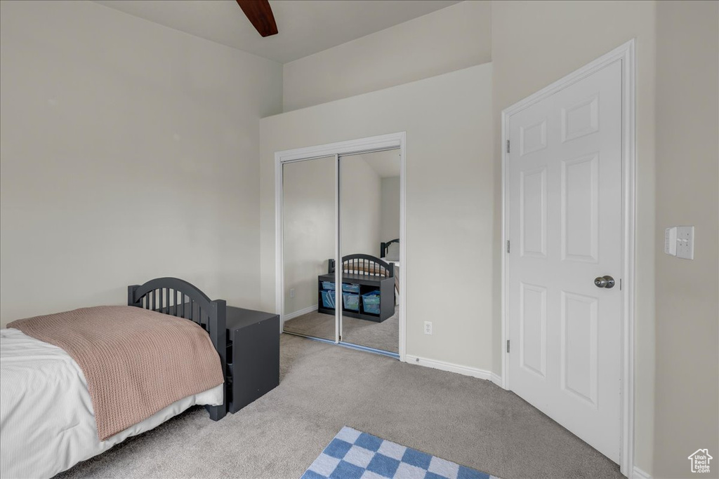 Bedroom featuring a ceiling fan, baseboards, carpet, and a closet