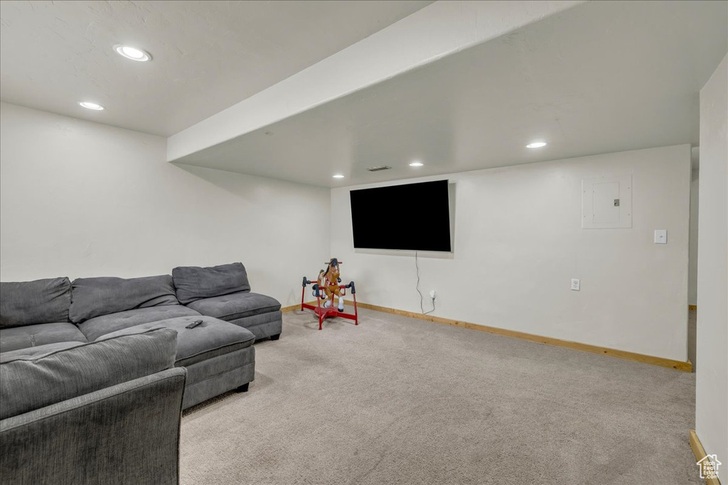 Carpeted living room featuring baseboards, electric panel, and recessed lighting