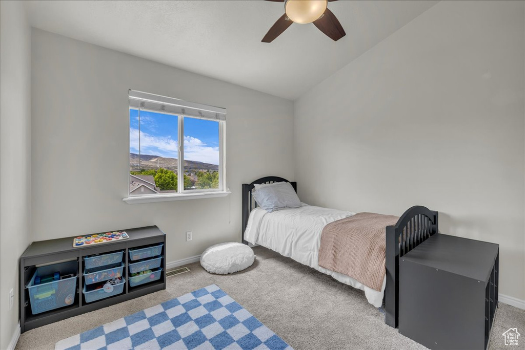Carpeted bedroom with baseboards, ceiling fan, and lofted ceiling