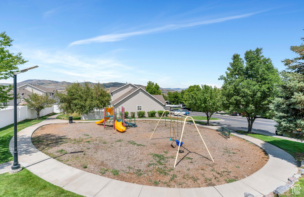 Exterior space featuring fence, a mountain view, and playground community