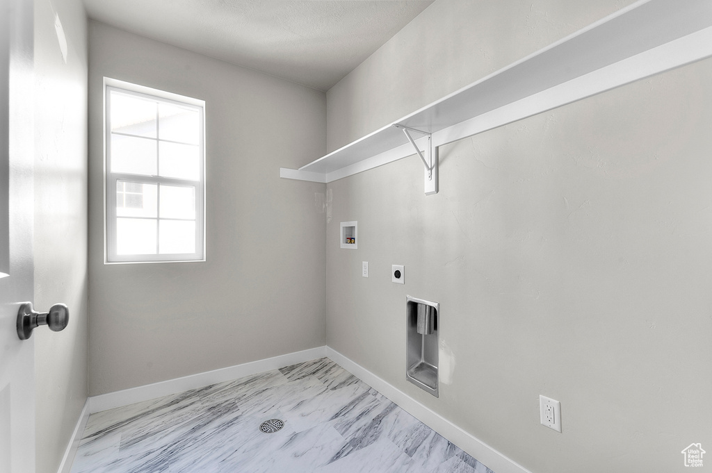Laundry room featuring washer hookup, light marble finish flooring, electric dryer hookup, and baseboards